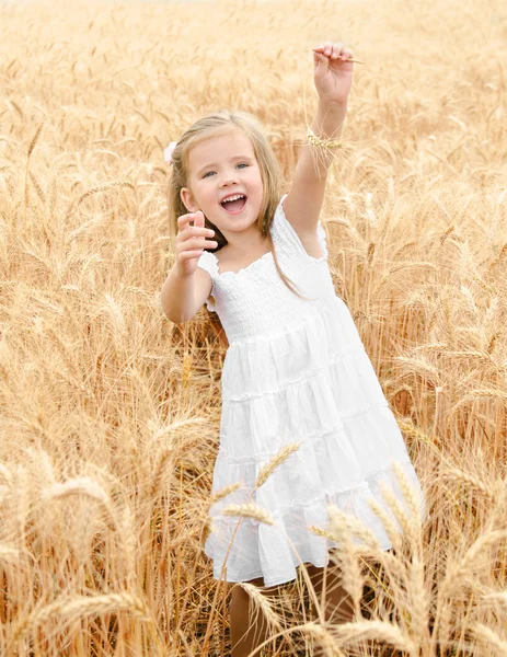 Bedårande leende liten flicka i fältet vete — Stockfoto