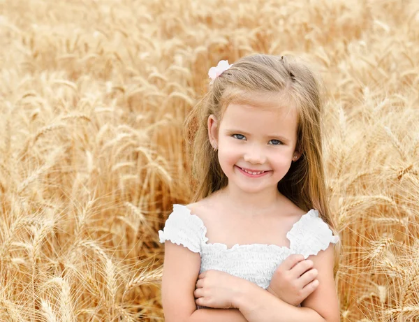 Buğday alanında gülümseyen sevimli küçük kız — Stok fotoğraf