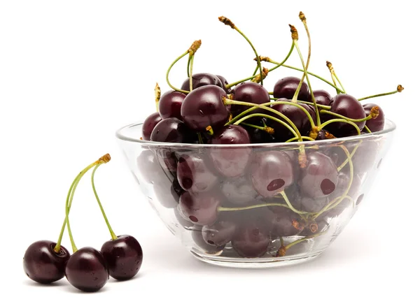 Un tazón de vidrio lleno de cerezas dulces aisladas — Foto de Stock