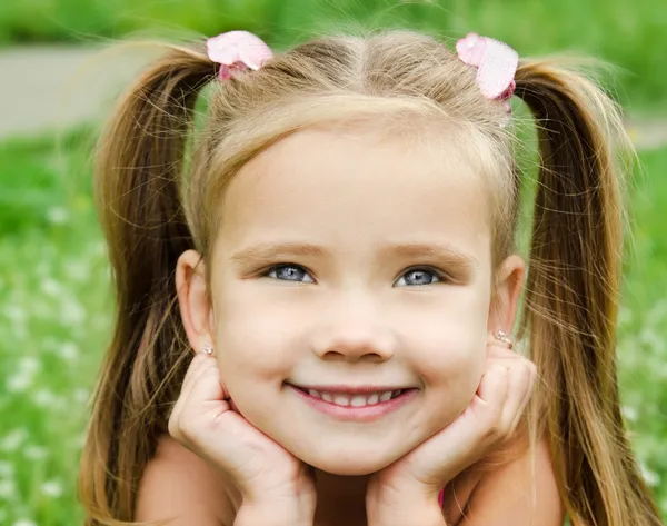 Милая улыбающаяся маленькая девочка на лугу — стоковое фото