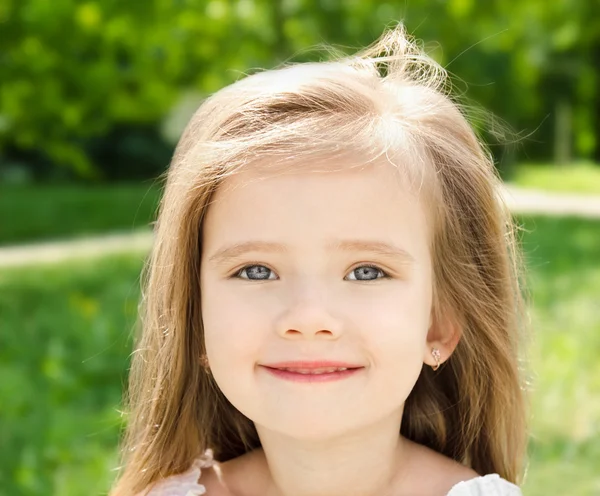 Внешний портрет очаровательной улыбающейся маленькой девочки — стоковое фото