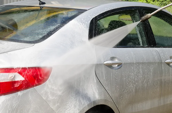 Manual car washing cleaning with foam and pressured water at ser — Stock Photo, Image