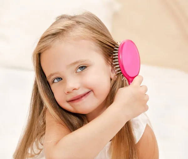 Retrato de una niña sonriente cepillándose el pelo — Foto de Stock