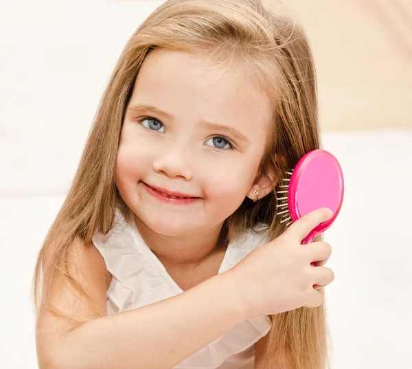 Porträtt av leende liten flicka borsta håret — Stockfoto