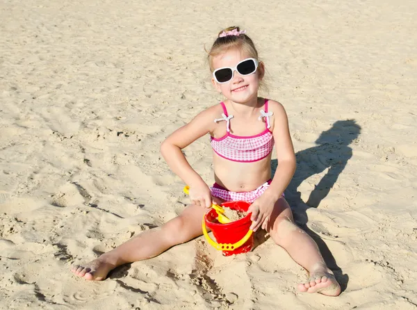 Усміхнена дівчинка грає на пляжі — стокове фото