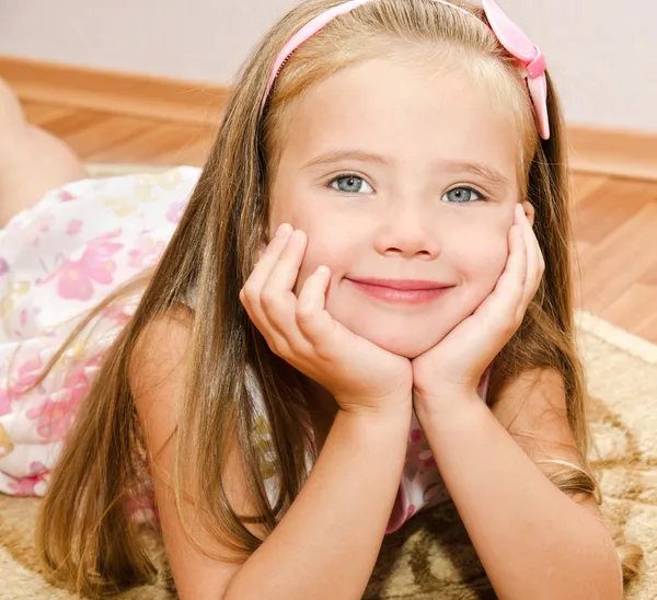 Schattig klein meisje ligt op een huis vloer — Stockfoto