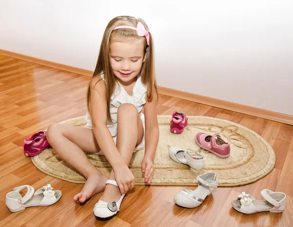 Cute little girl puts her shoes — Stock Photo, Image