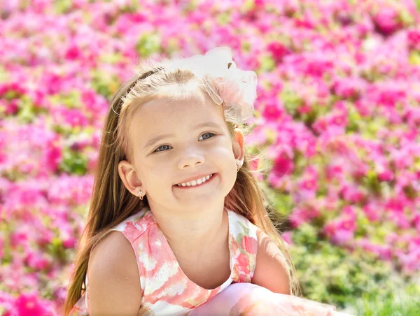 Zewnątrz portret cute dziewczynka w pobliżu kwiaty — Zdjęcie stockowe