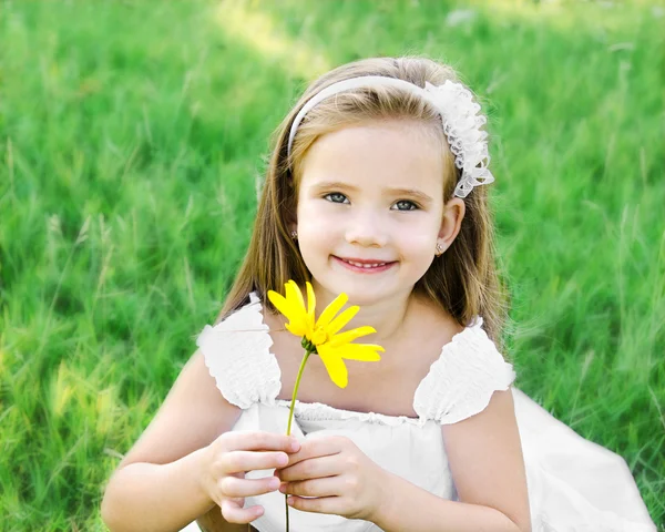 Linda niña en el prado con flor — Foto de Stock