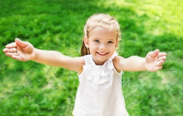 Милая улыбающаяся маленькая девочка, протягивающая руки — стоковое фото