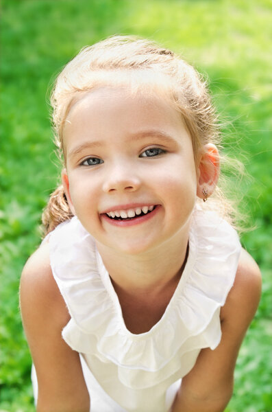 Cute smiling little girl on the meadow
