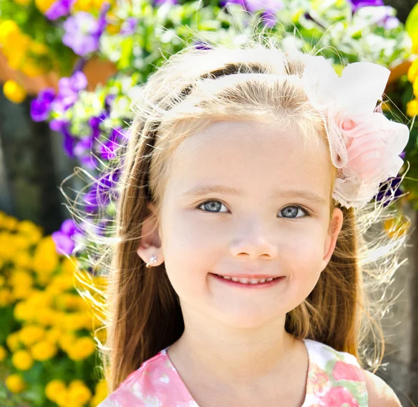 Außenporträt des niedlichen kleinen Mädchens in der Nähe der Blumen — Stockfoto