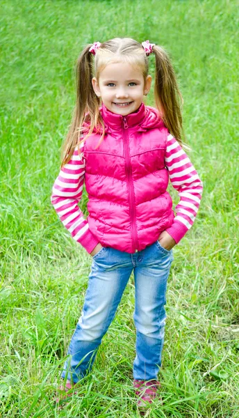 Sevimli küçük kız çayır çim yatan gülümseyen — Stok fotoğraf