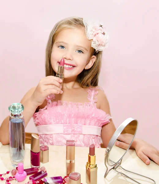 Kind cosmetica schattig klein meisje met lippenstift — Stockfoto