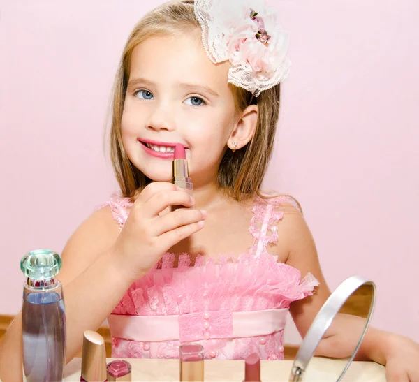 Kind cosmetica schattig klein meisje met lippenstift — Stockfoto