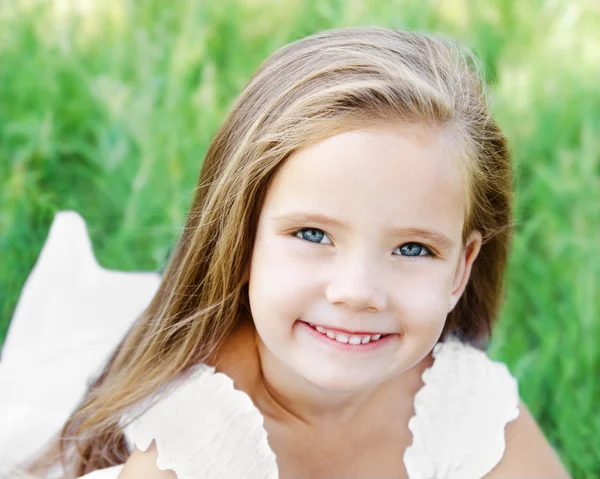 微笑着可爱的小女孩在草地上 — 图库照片