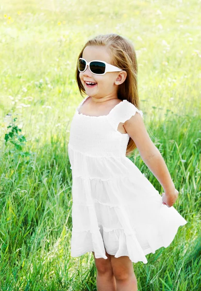 Felice ragazza carina in occhiali da sole sul prato — Foto Stock