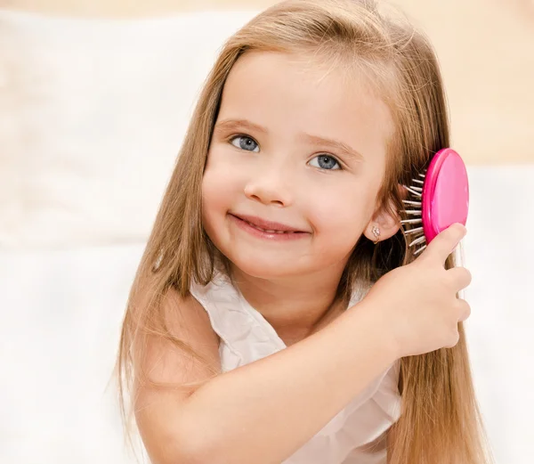 Retrato de una niña sonriente cepillándose el pelo — Foto de Stock