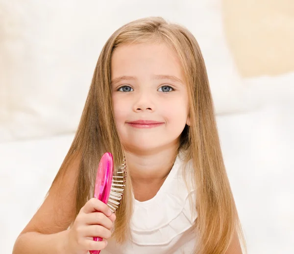 Portret van lachende meisje haar haren borstelen — Stockfoto