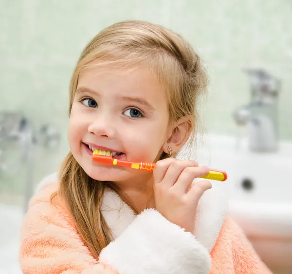 Sonriente niña cepillándose los dientes — Foto de Stock