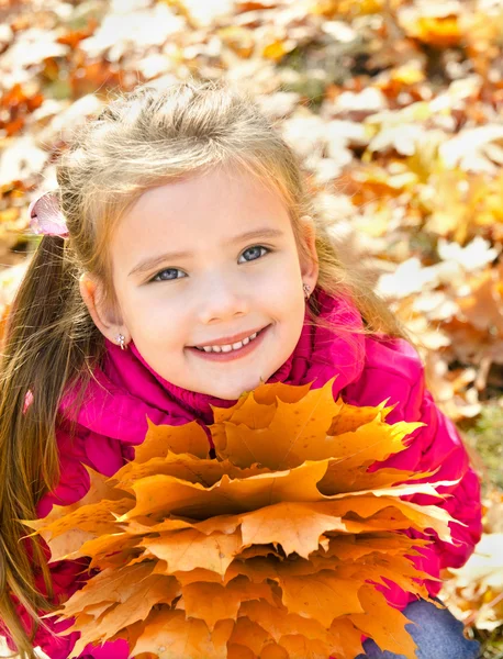 Autumn portrait of cute smiling little girl with maple leaves — Stock Photo, Image