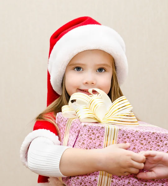 Glada leende liten flicka med julklapp — Stockfoto