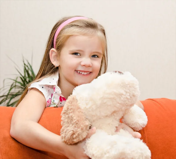 Милая улыбающаяся маленькая девочка развлекается со своей игрушкой — стоковое фото