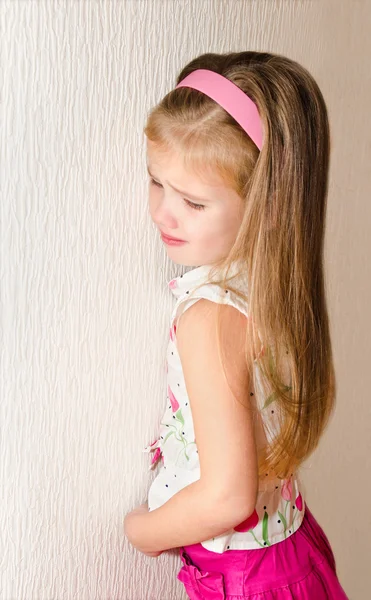 Непослушная маленькая девочка стоит в углу — стоковое фото