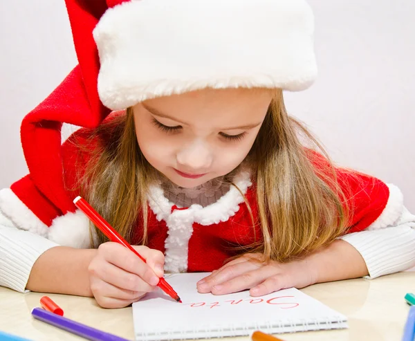 Little girl writes letter to Santa Stock Image