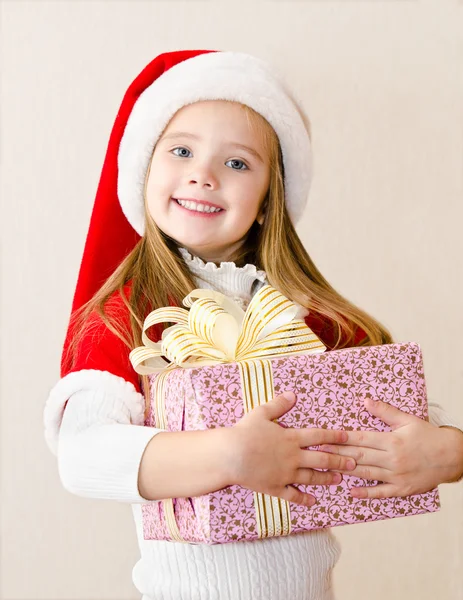 Glücklich lächelndes kleines Mädchen mit Weihnachtsgeschenk — Stockfoto
