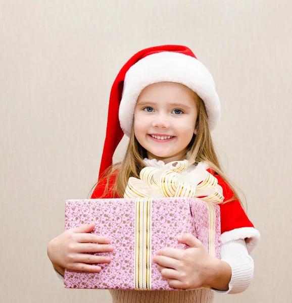 Glücklich lächelndes kleines Mädchen mit Weihnachtsgeschenk — Stockfoto