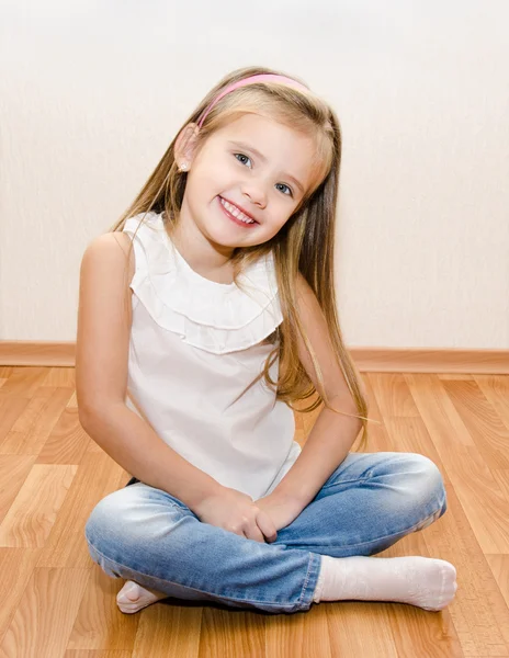 Lachende schattig klein meisje, zittend op de vloer — Stockfoto