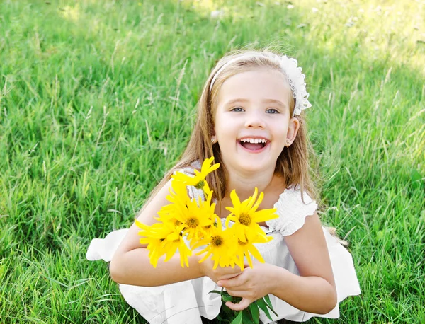 Ragazzina carina sul prato con fiore nel giorno d'estate — Foto Stock