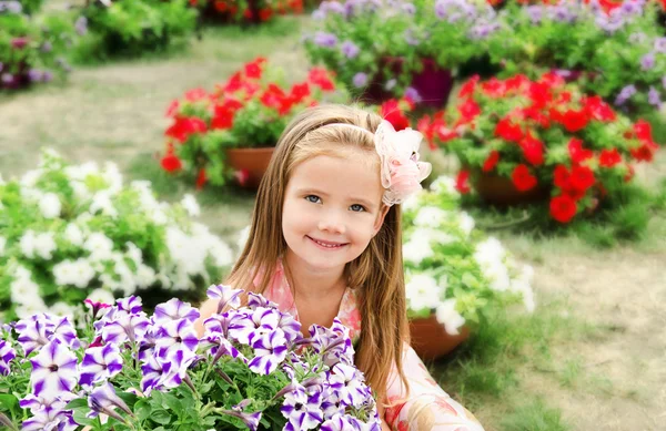 Outdoor portrait of cute little girl near the flowers — Stock Photo, Image