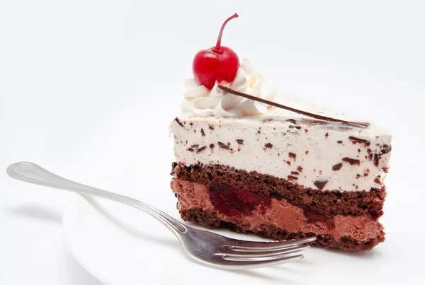 Segment van chocolate cake met kers op de plaat geïsoleerd — Stockfoto
