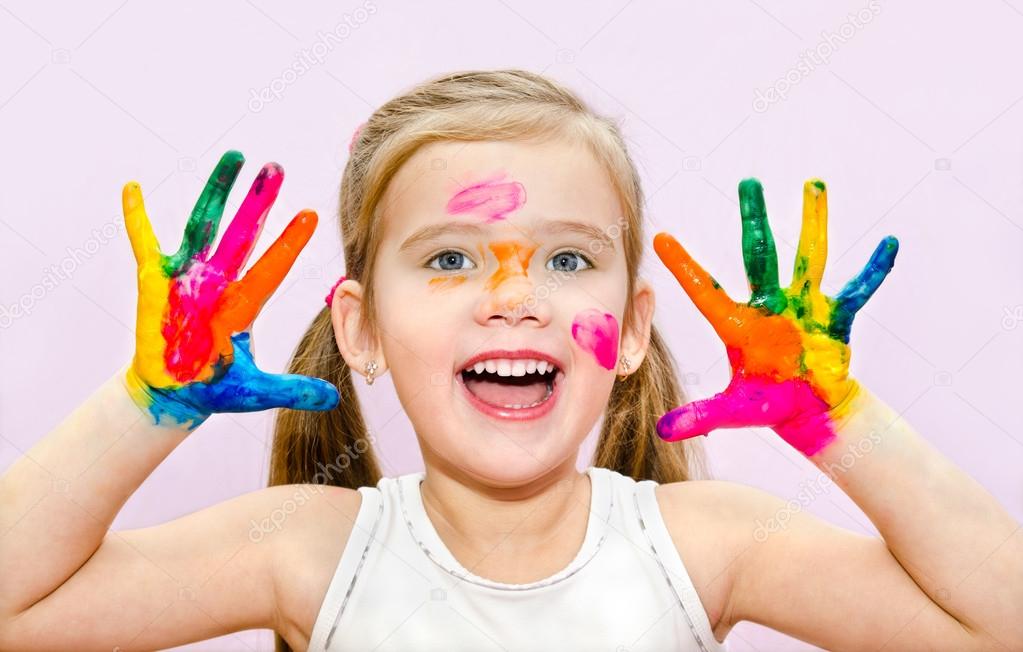 Cute smiling little girl with hands in paint