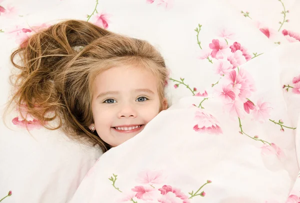 Очаровательная улыбающаяся маленькая девочка проснулась — стоковое фото