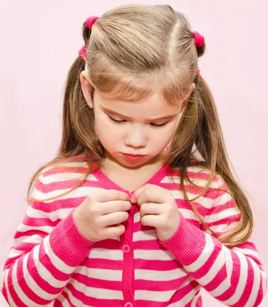 Niedliches kleines Mädchen knöpft sich ihre Jacke zu — Stockfoto