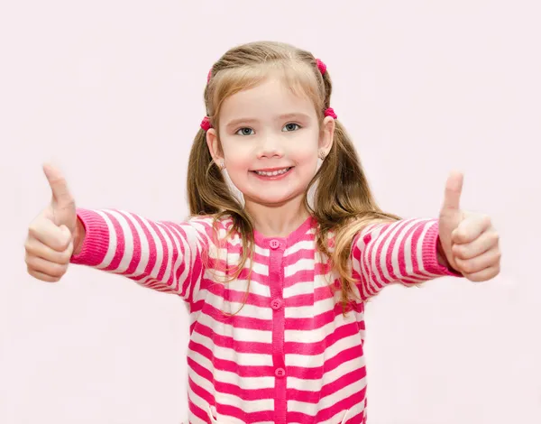 Niedliches glückliches kleines Mädchen mit hochgereckten Daumen — Stockfoto