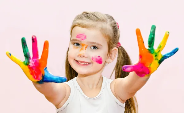 Carino sorridente bambina con le mani in vernice — Foto Stock