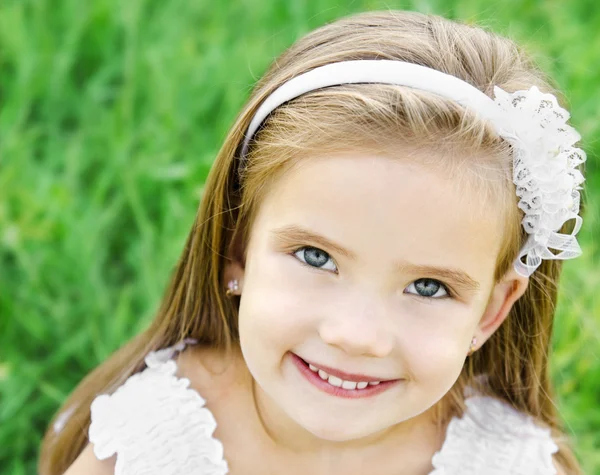 可爱微笑的小女孩在草地上 — 图库照片