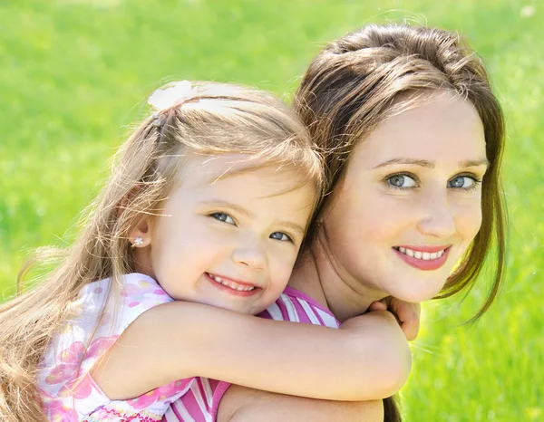 Retrato de una joven hermosa y sonriente y su pequeña hija —  Fotos de Stock