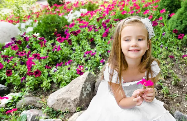 Bedårande liten flicka med blomma — Stockfoto