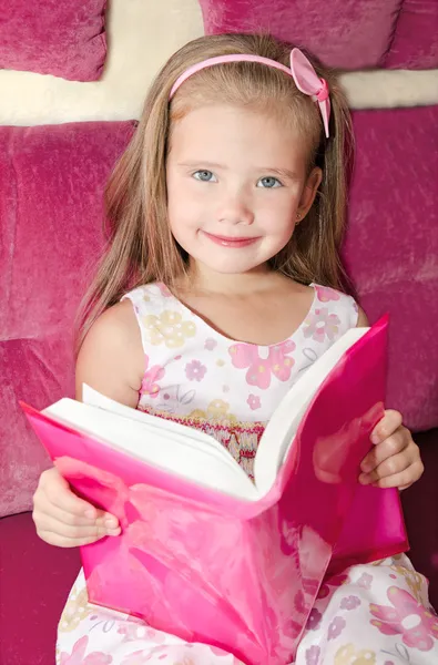 Linda niña sonriente leyendo un libro —  Fotos de Stock