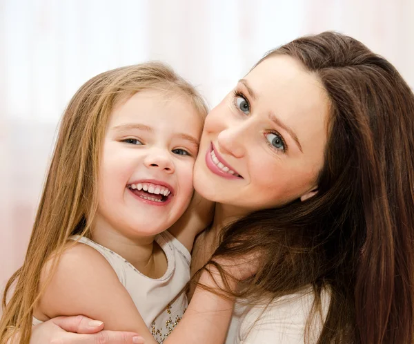 Lächelnde Mutter und ihr kleines Mädchen beim gemeinsamen Spielen — Stockfoto