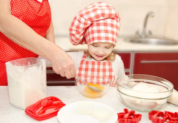 Liten flicka och mormor stirrring cookie doug — Stockfoto