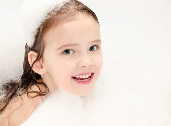Lachende meisje wassen in het bad met schuim — Stockfoto