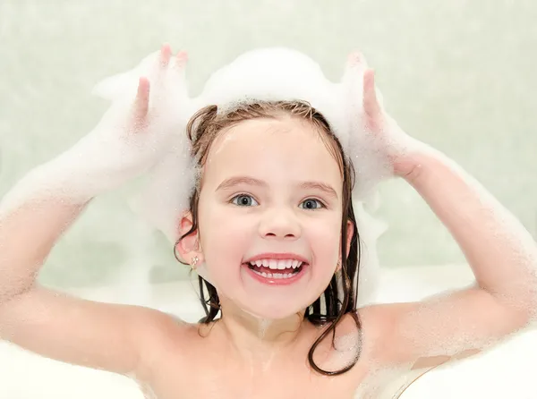 Glad liten flicka tvätt i badet med skum — Stockfoto