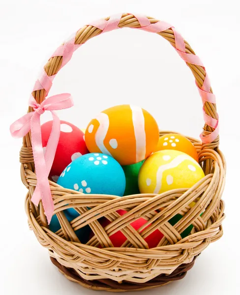 Colorful painted easter eggs in basket isolated — Stock Photo, Image