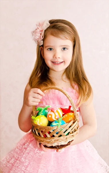 Little girl with basket full of colorful easter eggs — Stock Photo, Image